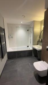 a bathroom with a tub and a toilet and a sink at Greenford Quay in Harrow on the Hill