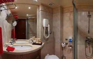 un baño con lavabo y ducha en Capitol Hotel, en Varna