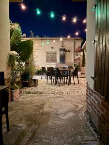 a patio with a table and chairs at night at Benvinguts Casa y Apartamentos de 1 a 12 personas Pleno Centro Santa Rosa de Calamuchita in Santa Rosa de Calamuchita
