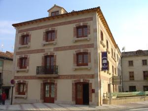 a large white building with windows on a street at Hospederia el Fielato in El Burgo de Osma