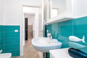 a bathroom with a white sink and a blue wall at Casa Andreale in Capoliveri