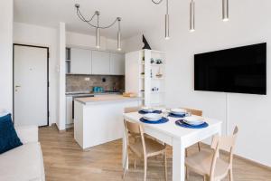 a kitchen and dining room with a white table and chairs at Casa Andreale in Capoliveri