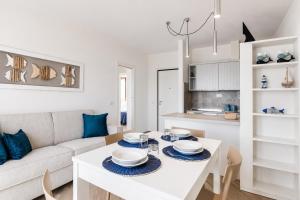 a living room with a white table and a couch at Casa Andreale in Capoliveri +23 photos