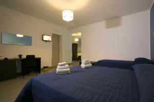 a bedroom with a blue bed with towels on it at Rotte e Sentieri B&B in Castelluzzo