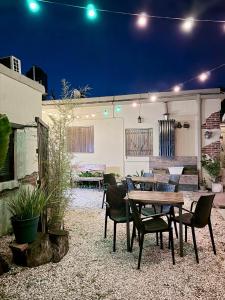a patio with a wooden table and chairs at night at Benvinguts Casa y Apartamentos de 1 a 12 personas Pleno Centro Santa Rosa de Calamuchita in Santa Rosa de Calamuchita