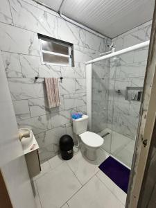 a bathroom with a toilet and a glass shower at Mirante Itajubá in Barra Velha +9 photos