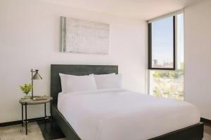 a bedroom with a large white bed and a window at Ida Phoenix in Phoenix