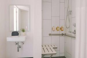 a white bathroom with a sink and a shower at Ida Phoenix in Phoenix