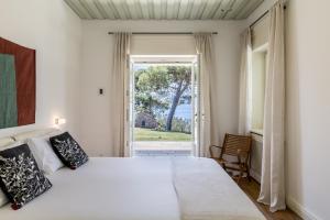 a bedroom with a large bed and a large window at Villa Avola Bol Exclusive Beach Access in Bol