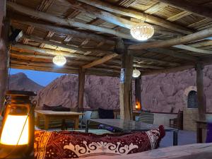 a living room with a table and a stone wall at maison isabel in Boumalne Dades