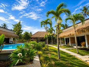 a resort with a swimming pool and palm trees at Anaiah Garden Resort in Moalboal