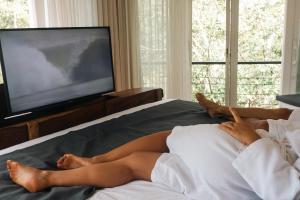 a woman laying on a bed with her feet up at Mikado Natural Lodge in Playa Avellana +131 photos