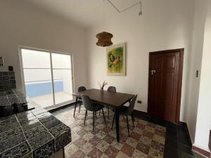 a dining room with a table and chairs and a window at Departamento 101 Casona Catalina in Puebla