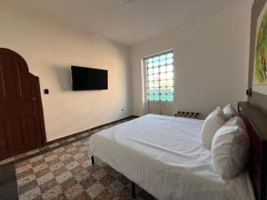 a bedroom with a bed and a television on the wall at Departamento 101 Casona Catalina in Puebla +4 photos