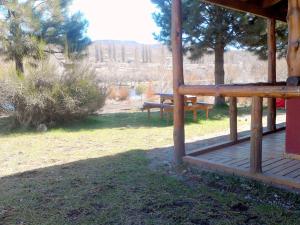 a wooden porch of a cabin with a picnic table at Cabañas El Puente Azul in Aluminé