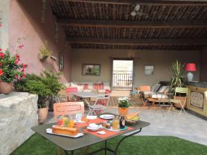 un patio con una mesa con comida. en Eden Roque, en La Roque-d'Anthéron