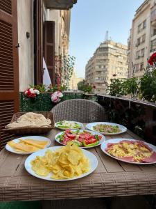 a wooden table with plates of food on it at Via Cairo hotel in Cairo
