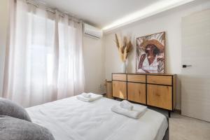 a bedroom with a bed and a dresser with towels at Villa Cobo in Torremolinos