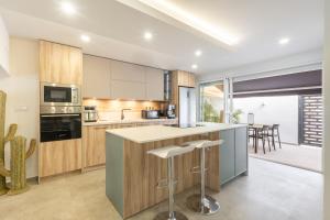 an open kitchen with a island with bar stools at Villa Cobo in Torremolinos