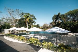 a resort with a pool and umbrellas at Mikado Natural Lodge in Playa Avellana