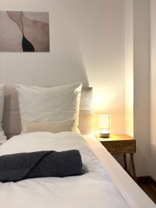 a white bed with a black blanket on top of it at City Loft Traum Quartier Apartments in Siegen