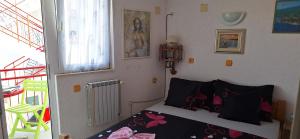 a bedroom with a bed with black and pink sheets at Apartman's Villi in Jadranovo