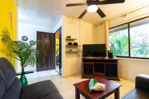 a living room with a couch and a flat screen tv at Casa Caribbean Coconut in Cahuita