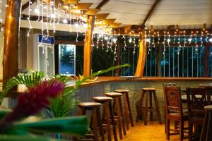 a bar with stools and lights in a restaurant at Casa Caribbean Coconut in Cahuita
