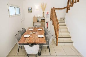 a dining room with a wooden table and chairs at Villa Mascareignas - Le Tampon in Le Tampon