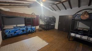 a room with two bunk beds and a wooden floor at Pisac cosmic in Pisac +5 photos