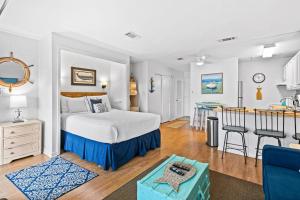 a bedroom with a large bed and a kitchen at Coastal Condo with heated pool hot tub tennis & beach access in Destin