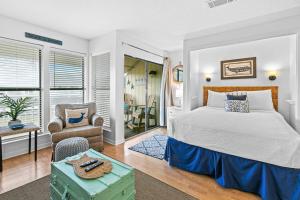 a bedroom with a king sized bed and a chair at Coastal Condo with heated pool hot tub tennis & beach access in Destin