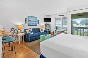 a living room with a blue couch and a table at Coastal Condo with heated pool hot tub tennis & beach access in Destin