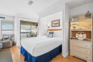 a bedroom with a large bed and a chair at Coastal Condo with heated pool hot tub tennis & beach access in Destin +19 photos