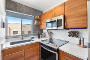 a kitchen with a sink and a microwave at DTPH Cozy Corner - Pool & Parking in Phoenix