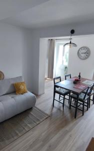 a living room with a table and a couch at L'olivier de Jeanine in Contes