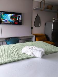 a bedroom with a bed with a tv on the wall at Flat 4 Mares - Refugio a dois - Com piscina e estacionamento em Intermares in Cabedelo +18 photos