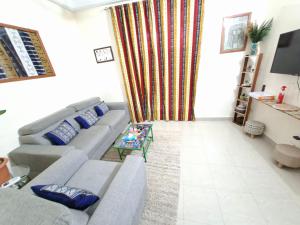 ein Wohnzimmer mit Sofa und Tisch in der Unterkunft Téranga Home Cosy & Spacieux à 600m de la plage in Dakar