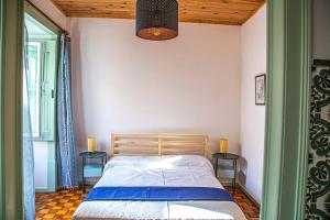 a bedroom with a bed and two tables at Casa do Arco da Vila in Faro