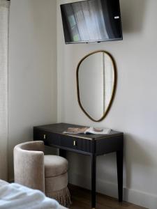 a black desk with a mirror and a chair at Carland Cottage in Carland +4 photos