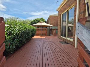 a wooden walkway with an umbrella on a building at Leopold holiday home in Leopold