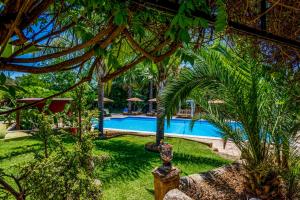 a resort with a swimming pool and palm trees at Emesh Boutique Suite in Agrigento
