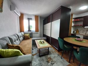 a living room with a couch and a table at Apartment Meri with garage in Velika Kladuša
