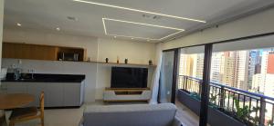 a living room with a television and a balcony at Opus Gyro Vaca Brava Designer in Goiânia