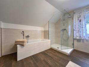 a white bathroom with a tub and a shower at Bayerischer Wald in Waldkirchen +28 photos