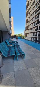 a row of blue benches on a building with buildings at Opus Gyro Vaca Brava Designer in Goiânia