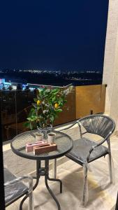 a glass table and chairs on a balcony with a view at Toot Suites in Abha