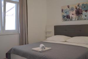 a bedroom with a bed with a towel on it at Apartments and rooms by the sea Nevidjane, Pasman - 11902 in Neviđane