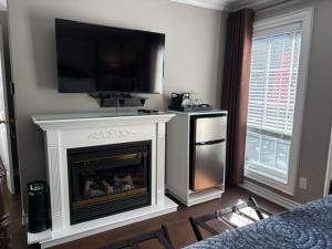 a living room with a fireplace with a tv above it at Casa Blanca Boutique Bed & Breakfast in Niagara-on-the-Lake