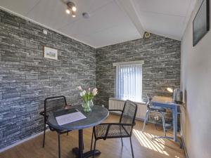 ein Zimmer mit Tisch und Stühlen und einer Backsteinwand in der Unterkunft Hoevendeel in Eefde